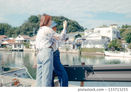 旅途中,一位六十多歲的老人和一位二十多歲的女子正在看智慧型手機。 旅途中,一位六十多歲的老人和一位二十多歲的女子正在看智慧型手機。 133713255