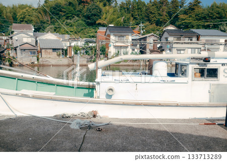A fishing boat moored in the harbor and a calm seascape 133713289