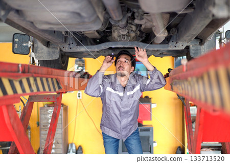 Automobile technician inspects the vehicle suspension. 133713520