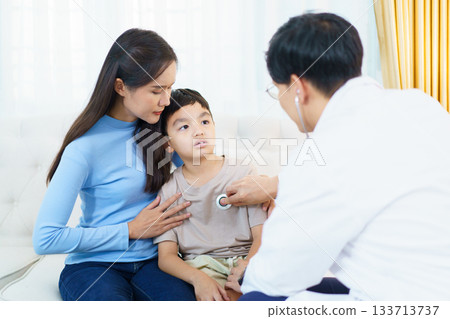 A doctor is performing a health check-up on a young boy, using a stethoscope to listen to his breathing and heartbeat. A doctor is performing a health check-up on a young boy, using a stethoscope to listen to his breathing and heartbeat. 133713737