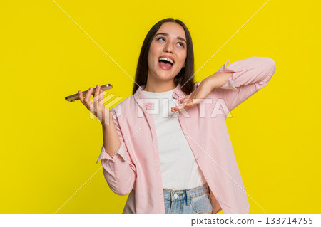 Woman dancing rhythmically to music playing from smartphone joyful energetic expressive cheerful 133714755