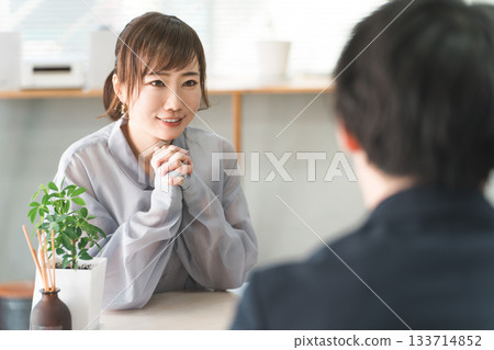 Female customer listening to a salesperson at a business meeting table Female customer listening to a salesperson at a business meeting table 133714852