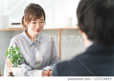 Female customer listening to a salesperson at a business meeting table 133714853