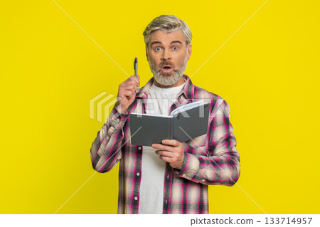 Mature man making notes writing thoughts with pen into notepad notebook diary to do list good idea 133714957