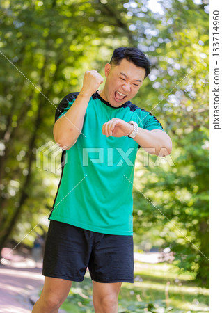 Athletic fitness sport runner winner Asian man finishing victory racing competition cardio training 133714960