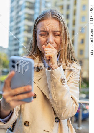 Upset businesswoman using smartphone browsing, loses becoming shocked bad news on downtown street 133714962