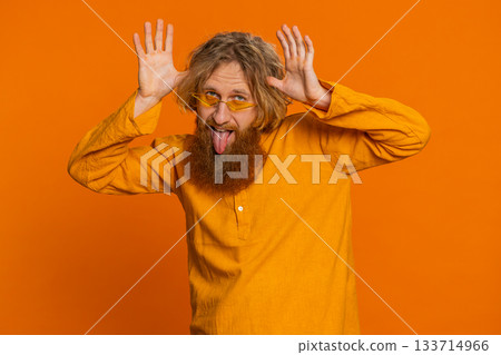 Funny comical Caucasian man making silly facial expressions grimacing fooling around showing tongue Funny comical Caucasian man making silly facial expressions grimacing fooling around showing tongue 133714966