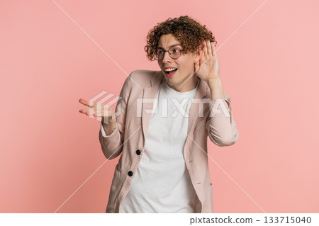 Caucasian man trying hear you looking confused and frowning, keeping arm near ear for louder voice Caucasian man trying hear you looking confused and frowning, keeping arm near ear for louder voice 133715040