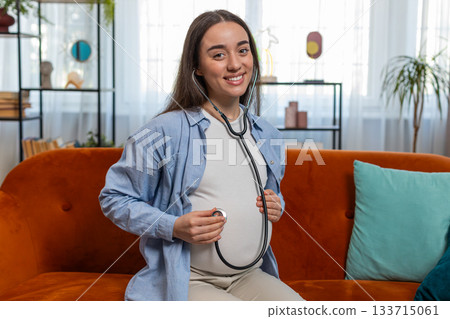 Happy pregnant young woman using stethoscope listening to baby heartbeat unborn child vital signs Happy pregnant young woman using stethoscope listening to baby heartbeat unborn child vital signs 133715061