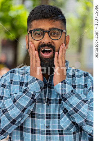 Indian man looking surprised at camera shocked by sudden win good victory news, wow in city street 133715066