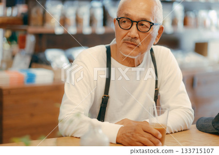 一位老人在咖啡館放鬆 一位老人在咖啡館放鬆 133715107