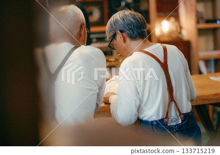 Relaxing time for senior couple enjoying magazines at cafe 133715219