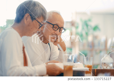 一對老年夫婦在咖啡館悠閒地讀雜誌 一對老年夫婦在咖啡館悠閒地讀雜誌 133715227