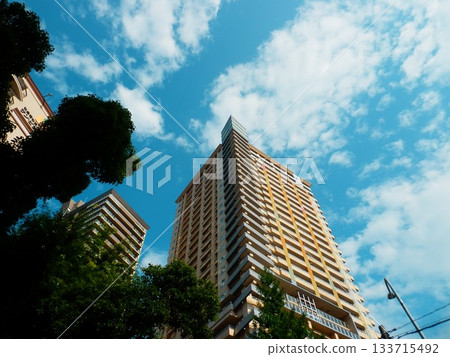 Tower apartment shining in the blue sky Tower apartment shining in the blue sky 133715492