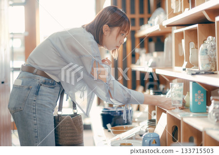 A local stroll scene featuring a woman in her twenties picking up cafe goods 133715503