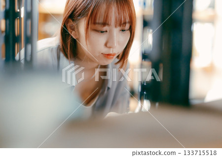 A local stroll scene featuring a woman in her twenties picking up cafe goods 133715518