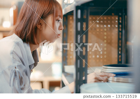 A local stroll scene featuring a woman in her twenties picking up cafe goods 133715519