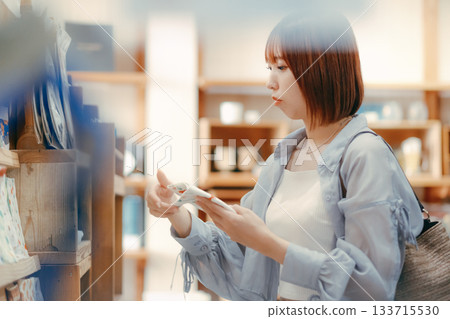 A local stroll scene featuring a woman in her twenties picking up cafe goods 133715530