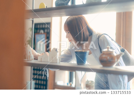 一幅當地居民漫步的場景,一位二十多歲的女性正在挑選咖啡館的商品。 一幅當地居民漫步的場景,一位二十多歲的女性正在挑選咖啡館的商品。 133715533