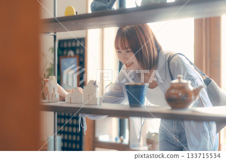 A local stroll scene featuring a woman in her twenties picking up cafe goods 133715534