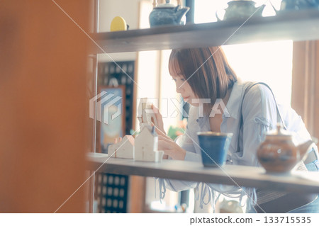 A local stroll scene featuring a woman in her twenties picking up cafe goods 133715535