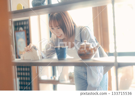 一幅當地居民漫步的場景，一位二十多歲的女性正在挑選咖啡館的商品。 133715536