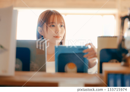 一位二十多歲的女性在共享辦公空間裡閱讀的場景 133715974