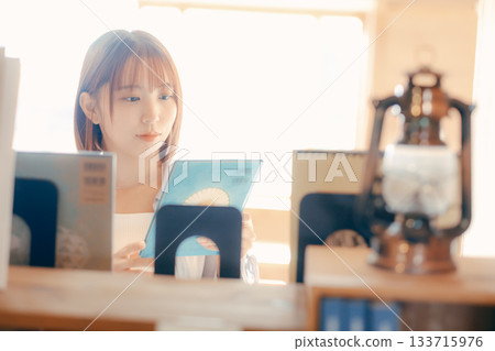 一位二十多歲的女性在共享辦公空間裡閱讀的場景 133715976