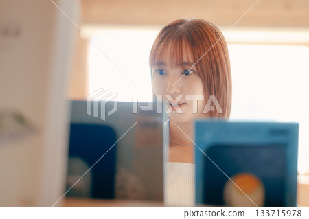 Scene of a woman in her twenties reading a book in a coworking space Scene of a woman in her twenties reading a book in a coworking space 133715978