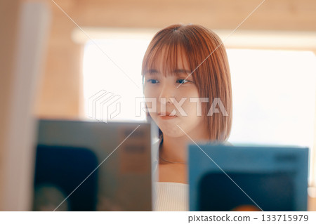 Scene of a woman in her twenties reading a book in a coworking space Scene of a woman in her twenties reading a book in a coworking space 133715979