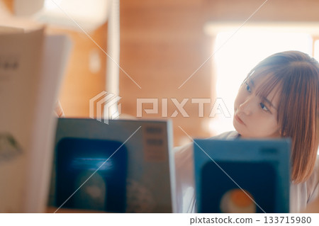 一位二十多歲的女性在共享辦公空間裡閱讀的場景 133715980