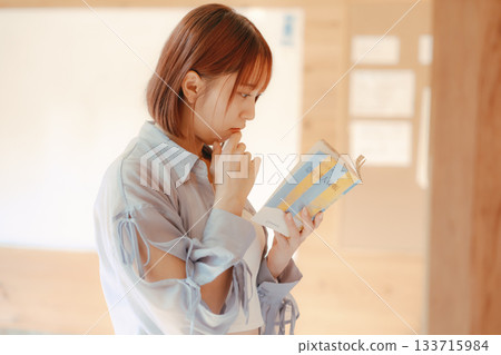 一位二十多歲的女性在共享辦公空間裡閱讀的場景 一位二十多歲的女性在共享辦公空間裡閱讀的場景 133715984
