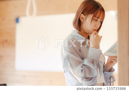 一位二十多歲的女性在共享辦公空間裡閱讀的場景 一位二十多歲的女性在共享辦公空間裡閱讀的場景 133715986