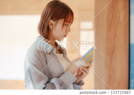 一位二十多歲的女性在共享辦公空間裡閱讀的場景 一位二十多歲的女性在共享辦公空間裡閱讀的場景 133715987