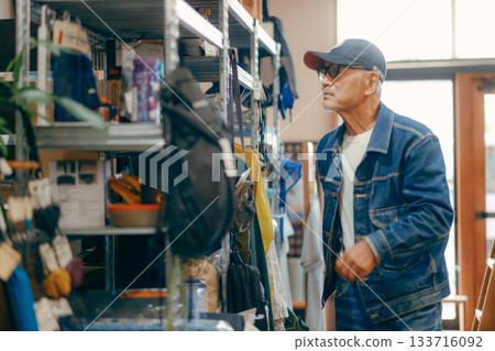 一個六十多歲的男人在商店裡拿起一本雜誌的典型場景 一個六十多歲的男人在商店裡拿起一本雜誌的典型場景 133716092
