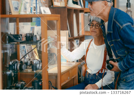Senior couple looking at vintage cameras at a camera store Senior couple looking at vintage cameras at a camera store 133716267