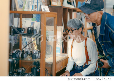 Senior couple looking at vintage cameras at a camera store Senior couple looking at vintage cameras at a camera store 133716268