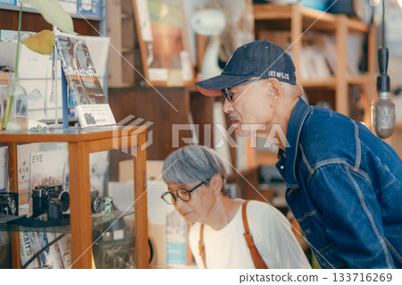 Senior couple looking at vintage cameras at a camera store Senior couple looking at vintage cameras at a camera store 133716269