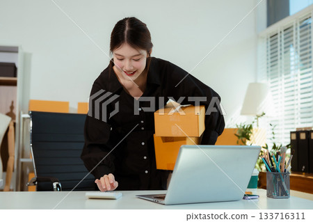 Entrepreneur women working at home about online business. Business owner woman using calculator and laptop working at home office. 133716311