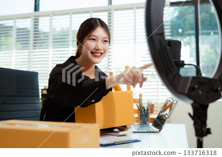 Asian vlogger woman influencer, SME retail store owner smile enjoy selling show live sale online screen smartphone. Asian vlogger woman influencer, SME retail store owner smile enjoy selling show live sale online screen smartphone. 133716318