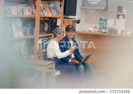 一對老年夫婦在咖啡館使用電腦和智慧型手機進行研究的場景 133716398