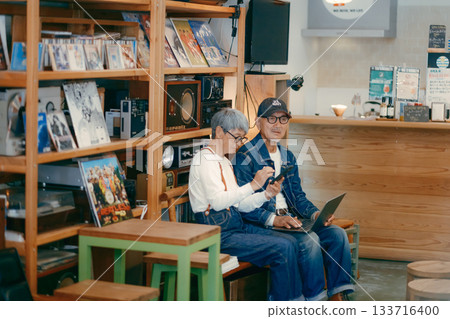 一對老年夫婦在咖啡館使用電腦和智慧型手機進行研究的場景 133716400