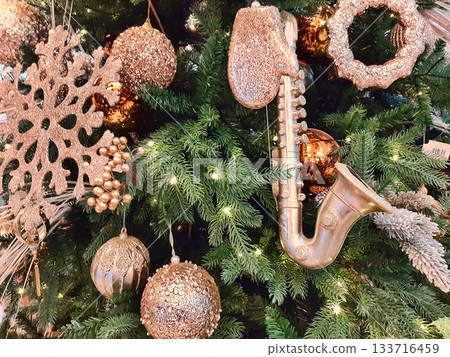 Christmas ornaments on the Christmas tree. Toys and gold stars. Christmas ornaments on the Christmas tree. Toys and gold stars. 133716459