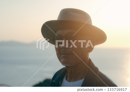 Portrait of a senior man looking out at the sea at sunset Portrait of a senior man looking out at the sea at sunset 133716917