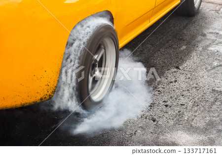 Drag racing car burns rubber off its tires in preparation for the race Drag racing car burns rubber off its tires in preparation for the race 133717161