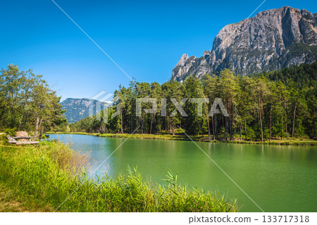 Alpine lake and high mountain ridges in Dolomites, Italy 133717318