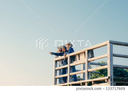 A twilight scene of a parent and child watching the sea at dusk 133717609