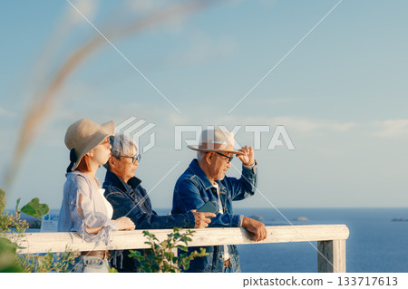A twilight scene of a parent and child watching the sea at dusk A twilight scene of a parent and child watching the sea at dusk 133717613