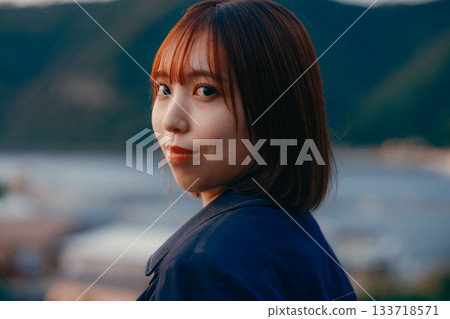Twilight portrait of a woman gazing at the sunset Twilight portrait of a woman gazing at the sunset 133718571