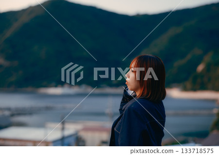 黃昏時分，一位女子凝視著落日。 133718575